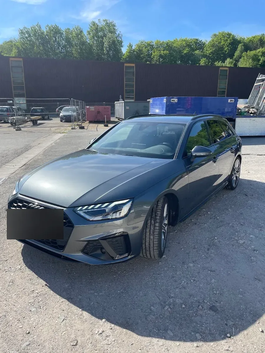 Dunkelgrauer Audi A4 Avant S-Line steht bei Sonne aufbereitet auf dem Hof, Lack und Felgen sauber.