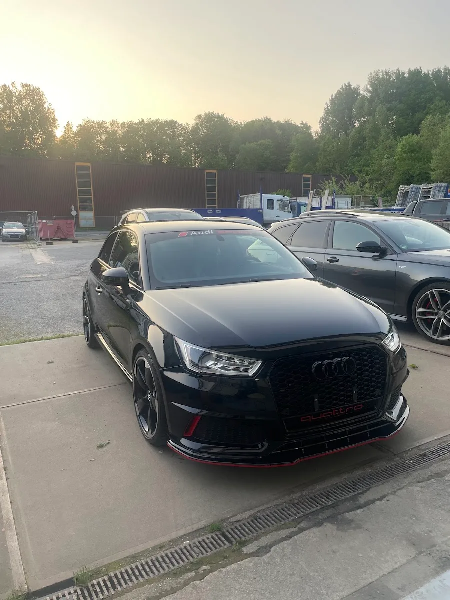 Schwarzer Audi S1 quattro in Dreiviertelansicht auf dem Hof im Abendlicht, Lack spiegelt sauber.