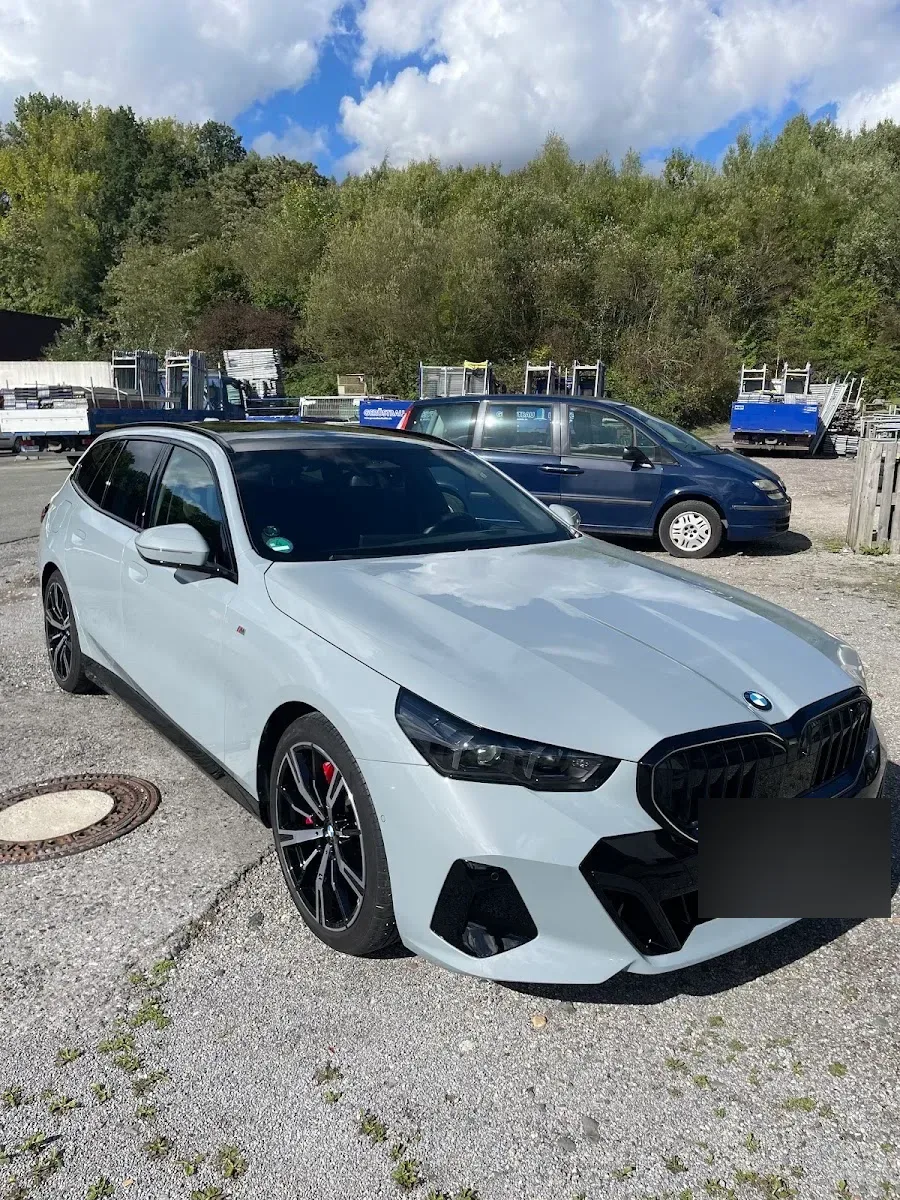 Hellgrauer BMW 5er Touring M-Paket bei Sonne auf dem Hof, Lack und schwarze Felgen frisch aufbereitet.