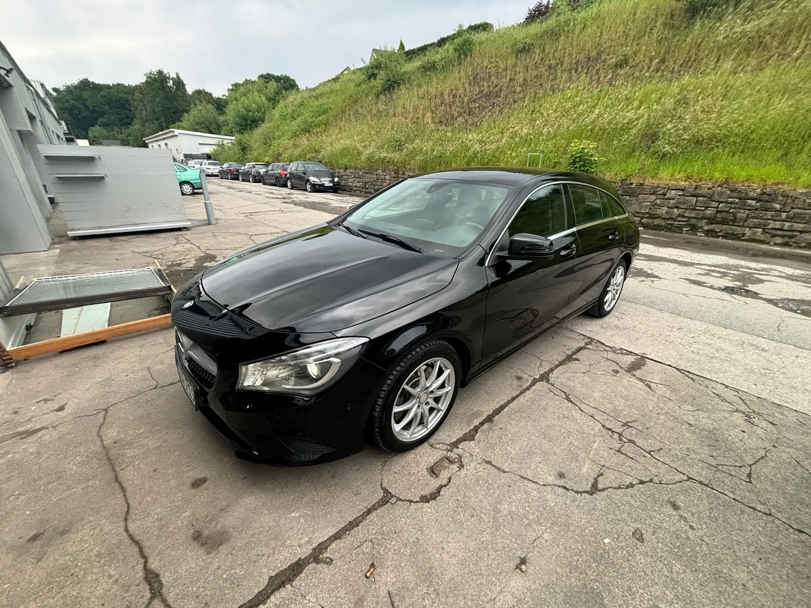Schwarzer Mercedes CLA Shooting Brake auf dem Hof, Lack durchgehend glaenzend mit klaren Reflexionen.