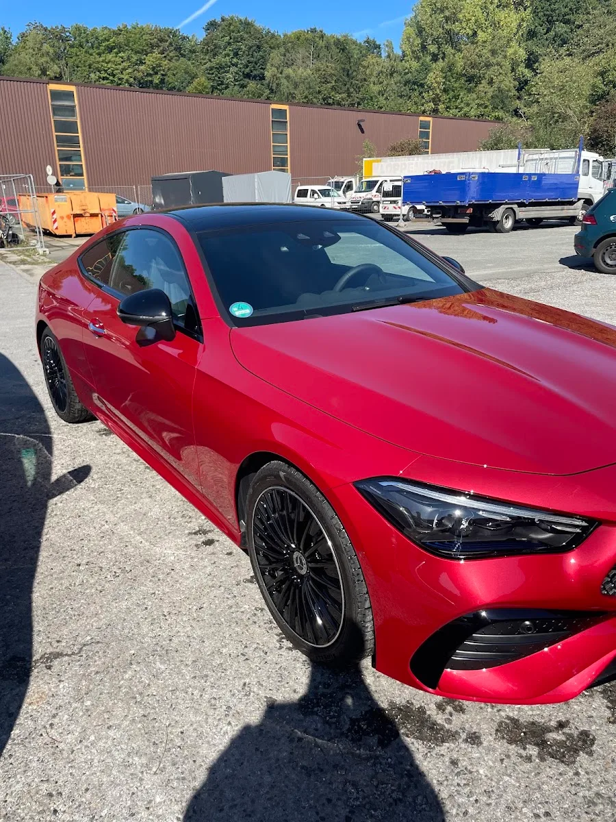 Roter Mercedes CLE Coupe mit schwarzen Felgen steht bei Sonne auf dem Hof, der Lack spiegelt stark nach der Aufbereitung.