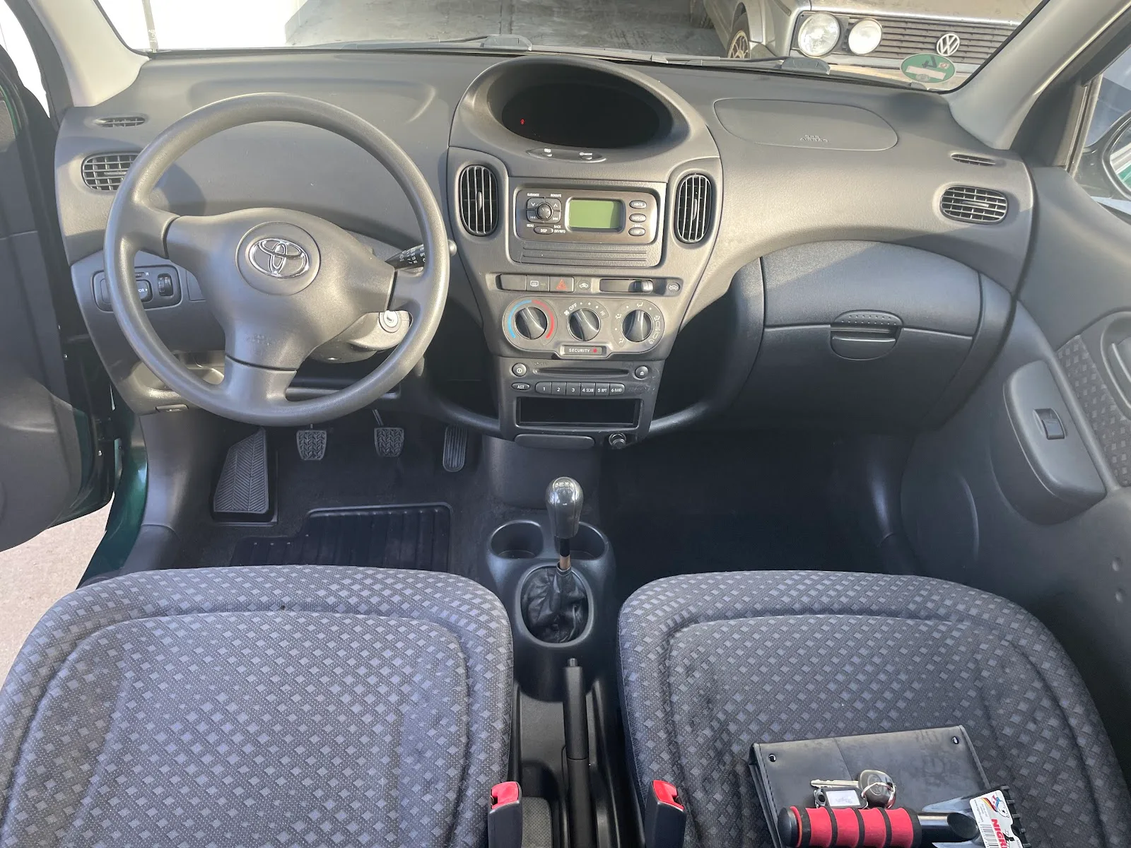 Gereinigtes graues Cockpit eines Toyota Yaris mit Stoffsitzen, sauberen Fussmatten und staubfreiem Armaturenbrett.