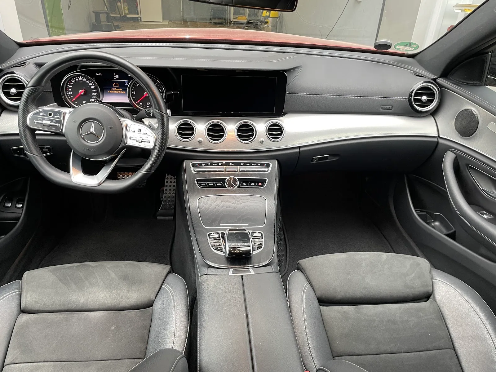Frisch gereinigtes Cockpit einer Mercedes E-Klasse mit staubfreiem Armaturenbrett, Lenkrad, Widescreen-Display und sauberer Mittelkonsole.