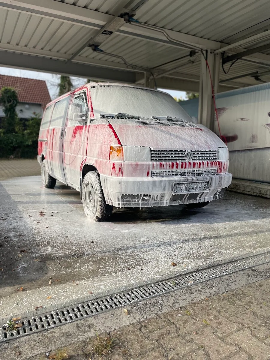 Rot-weisser VW T4 Transporter komplett mit Reinigungsschaum eingeschaeumt in der Waschbox.